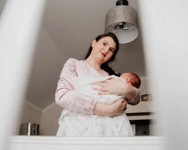 Matka tuli dziecko, które lekko się wierciło, jakby czuło stan podgorączkowy u niemowlaka.