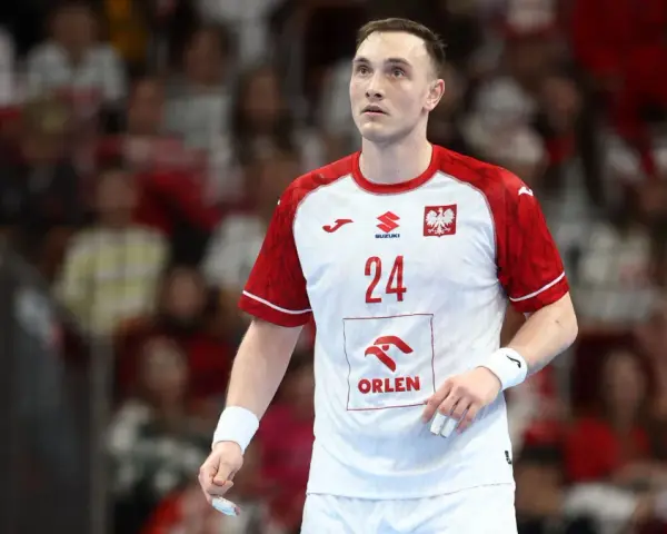 Wiktor Jankowski, numer 24, w białej koszulce z czerwonymi rękawami, z orłem na piersi, na tle trybun.