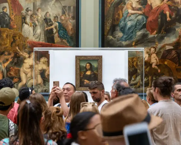Mona Lisa i Louvren, omgiven av besökare som fotograferar. Hur lång tid tog det att måla Mona Lisa? En evighet av konstnärlig genialitet.
