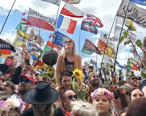 Tłum na festiwalu Poland Rock 2026, z flagami i słonecznikami. Ludzie cieszą się muzyką i atmosferą.