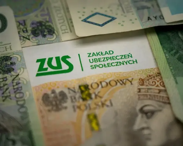 ZUS na tle polskich banknotów. Symbolizuje świadczenie rehabilitacyjne po ustaniu zatrudnienia, wsparcie finansowe w trudnych chwilach.