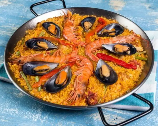 Paella mixta con gambas y mejillones, un festín de sabores mediterráneos en una paellera.