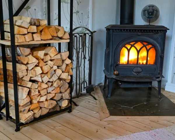 En kamin med glödande eld och en vedstapel redo för att installera kamin.