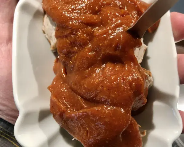 Eine Portion Currywurst mit viel Sauce, die Lust auf das Currywurst Rezept macht.