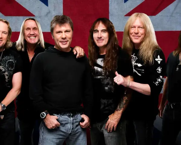Sechs Musiker der Band Iron Maiden posieren vor der britischen Flagge.