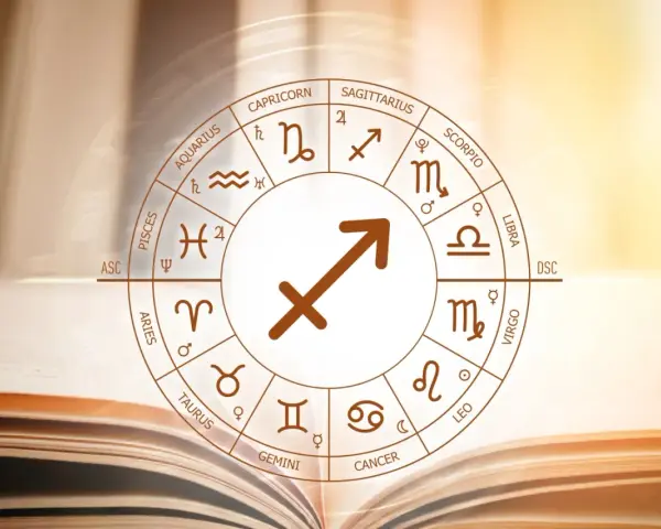 Koło zodiaku z symbolem strzelec znak zodiaku w centrum, na tle otwartej księgi.