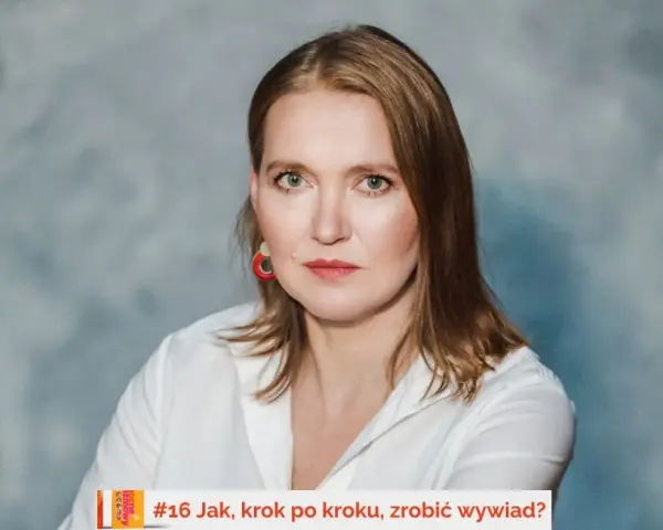 Kobieta w białej koszuli, z rudymi włosami i czerwoną biżuterią, udziela wywiadu. #16 Jak, krok po kroku, zrobić wywiad?