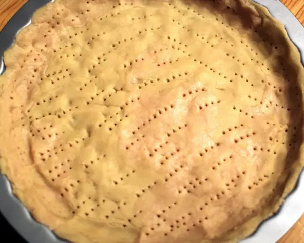 Surowy spód do tarty, z widocznymi dziurkami, czeka na nadzienie. Tarta na kruchym spodzie czy na cieście francuskim?