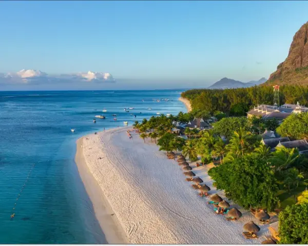 Rajska plaża na Mauritiusie, idealna temperatura do opalania. Woda kusi turkusowym blaskiem, a palmy szumią na wietrze.