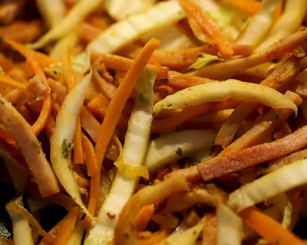 Pokrojone w słupki marchewka, fasolka i inne warzywa w daniu stir-fry.