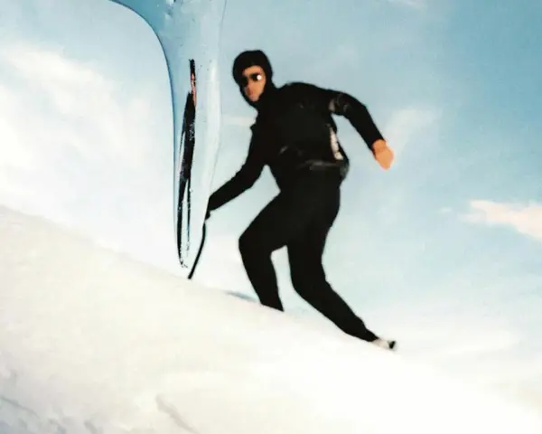 Kilian Jornet desciende el Mont Blanc con agilidad, su silueta negra contra la nieve y el cielo azul.
