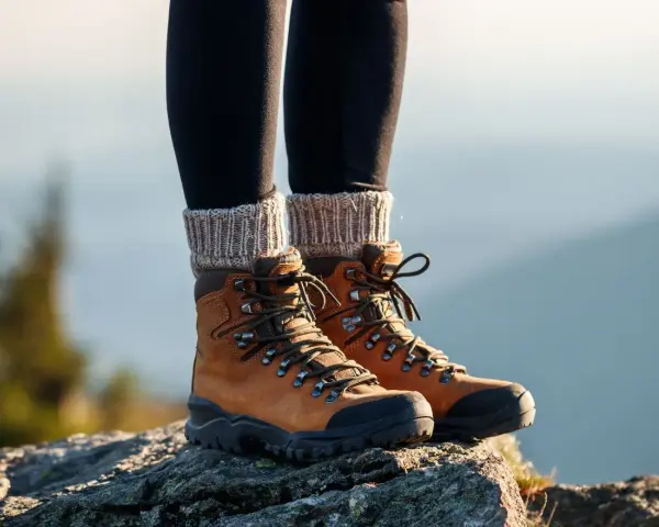 Brązowe buty trekkingowe na skale. Idealne na górskie wędrówki, sprawdź nasz ranking butów trekkingowych.