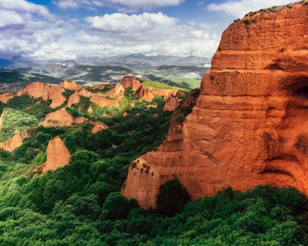 Paisaje dramático de Las Médulas, uno de los parques de España más impresionantes, con sus rocas rojizas y vegetación exuberante.