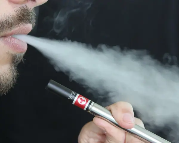Hombre exhalando vapor de un vaper Vuse. La resistencia del vaper permite una experiencia de vapeo suave.