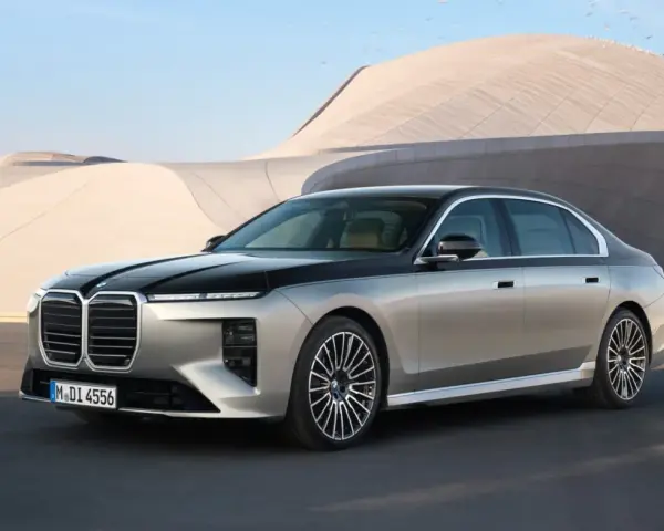 Elegancki BMW 740d w dwukolorowym malowaniu, zaparkowany przed nowoczesnym budynkiem.