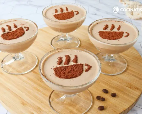 Cuatro copas de delicioso mousse de café, decoradas con cacao en polvo simulando una taza humeante.