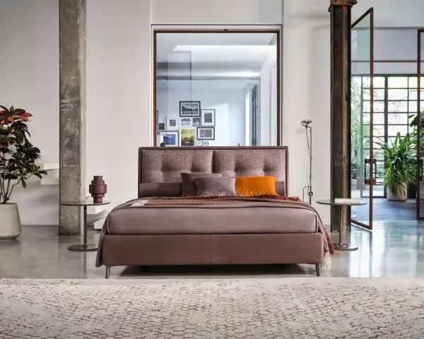 Elegante letto con testiera imbottita, parte di una collezione di **marchi camere da letto** di design.