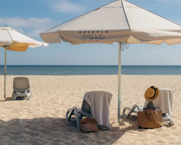 Leżaki i parasole na piaszczystej plaży nad morzem.