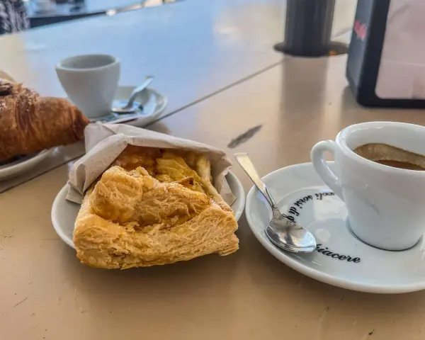 Ein Espresso und ein Croissant – so trinkt man in Italien! Dazu ein süßes Gebäck.