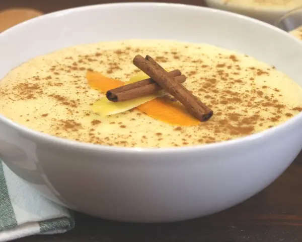 Delicioso arroz con leche thermomix, espolvoreado con canela y decorado con piel de naranja y limón.