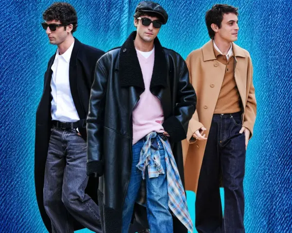 Tre uomini con un outfit elegante con jeans. Uno indossa un cappotto nero, camicia bianca e jeans grigi. Un altro un cappotto in pelle nero, maglione rosa e jeans blu. Il terzo un cappotto cammello, maglione marrone e jeans scuri.