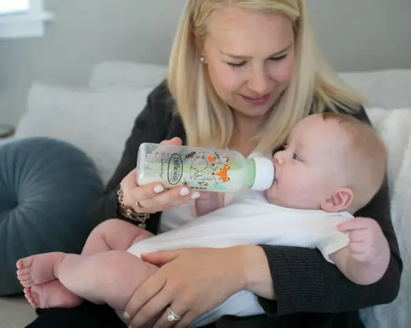 Mama karmi dziecko z butelki antykolkowej Dr Brown's z uroczym motywem lisów.
