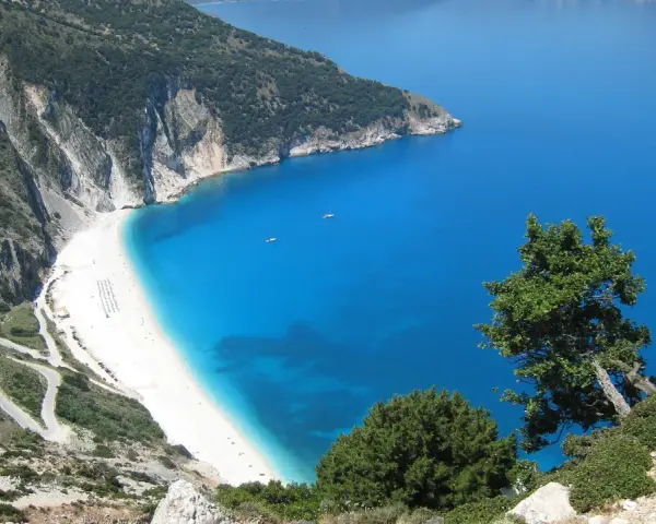 Malownicza plaża Myrtos na Kefalonii, Grecja w październiku. Kręta droga prowadzi do białego piasku i turkusowego morza.