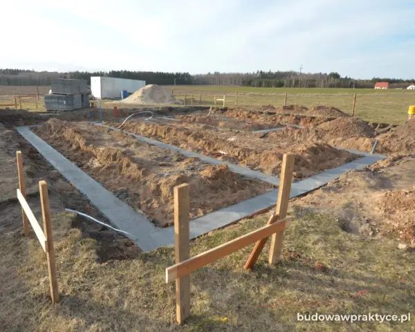 Rozpoczęto wylewanie fundamentu pod nowy dom. Wykopano rowy, w których widać świeży beton.