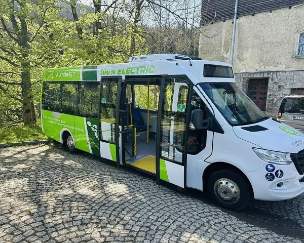 Zielony, elektryczny Automet gotowy do zabrania turystów na Morskie Oko. Ekologiczny transport w malowniczym otoczeniu.