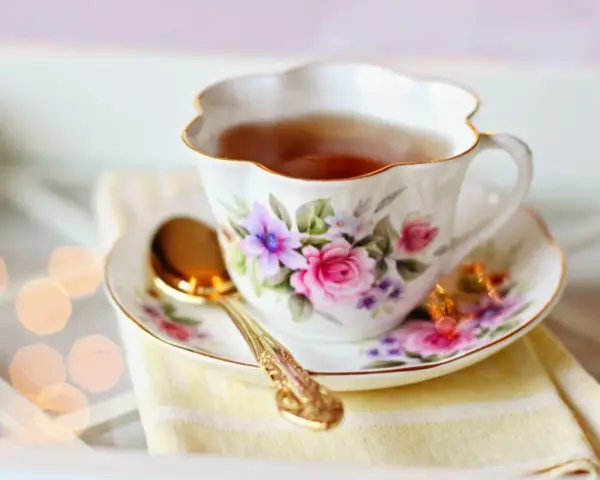 Elegancka filiżanka z kwiatowym wzorem, pełna aromatycznej herbaty. Czy herbata nawadnia? Ta z pewnością tak, dodając chwili relaksu.