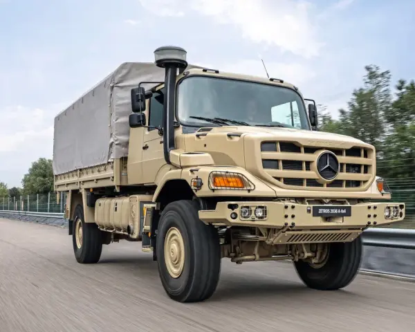 Beżowy Mercedes Zetros 2036 A 4x4 z plandeką jedzie po drodze, gotowy na każde wyzwanie.