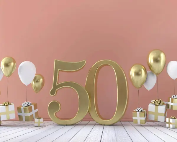 Złote myśli na 50 urodziny: złota liczba 50, balony i prezenty tworzą radosną atmosferę świętowania.