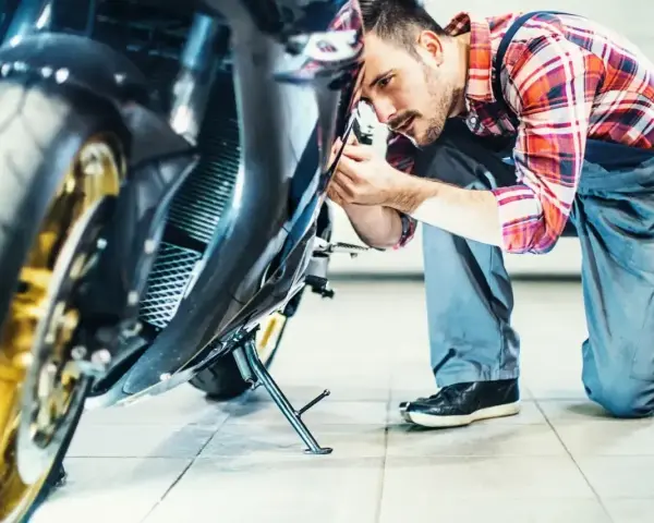 Mechanik sprawdza motocykl. Dowiedz się, ile kosztuje przegląd motocykla, zanim oddasz go do serwisu.