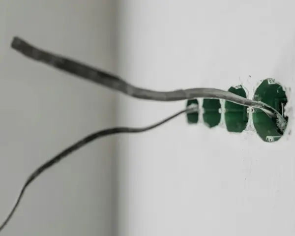 Instalacja elektryczna w ścianie z puszkami pod gniazdka. Uziemienie w gniazdku to klucz do bezpieczeństwa.