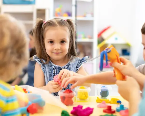 Dzieci bawią się plasteliną. Ile pieniędzy dostaje przedszkole na dziecko z orzeczeniem?