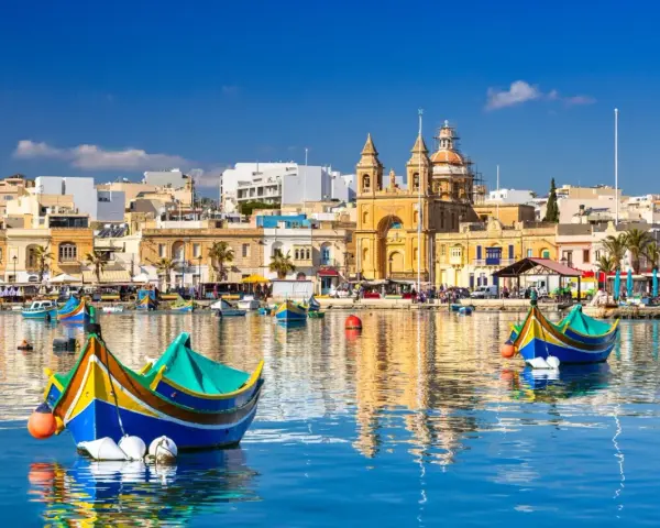 Malta: kolorowe łodzie luzzu w porcie, zabytkowa architektura i błękitne morze. Warto wiedzieć, że to malownicze widoki!