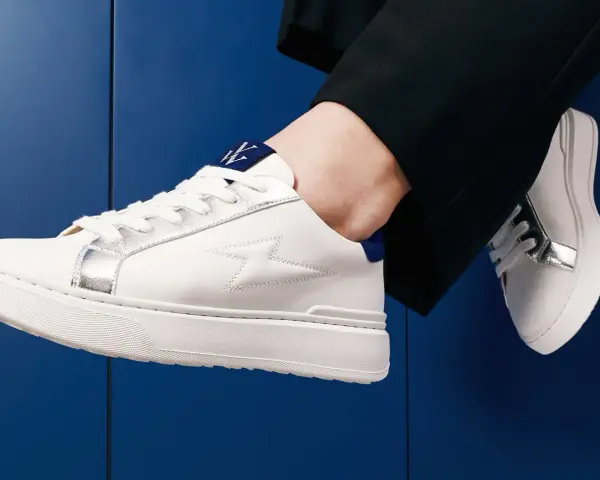 Une tenue chic avec une basket blanche femme, ornée d'éclairs argentés et d'un logo bleu. Parfait pour un look moderne.