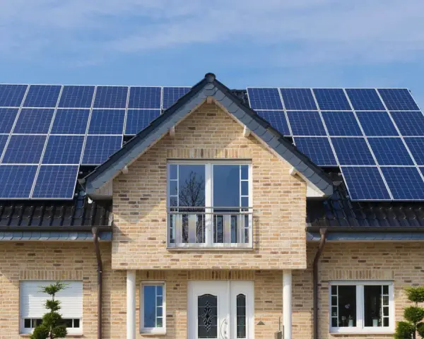 Dom z panelami fotowoltaicznymi na dachu. PV co to? To panele słoneczne, które produkują czystą energię.