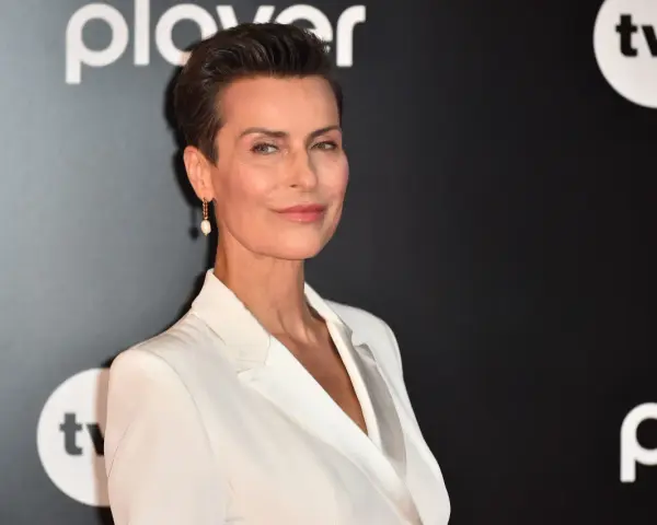 Danuta Stenka w białej kreacji, gwiazda filmów, seriali i programów, na tle logo TVN i Playera.
