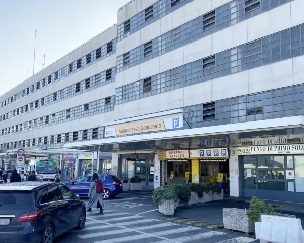 Ingresso Autorimessa Comunale a Piazzale Roma, Venezia. Un'ambulanza e auto parcheggiate.