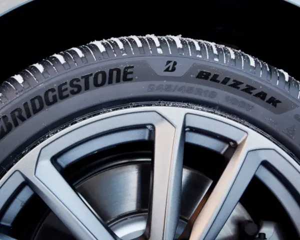 Opony zimowe Bridgestone Blizzak na feldze, pokryte śniegiem. Wiele pozytywnych opony Bridgestone opinie potwierdza ich jakość.