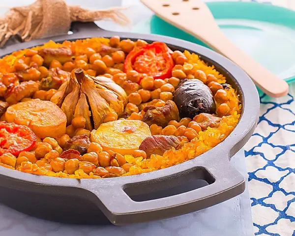 Arroz al horno valenciano con garbanzos, tomate, patata, ajo y morcilla en una paellera.