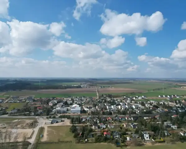 Krajobraz z zabudowaniami i polami. Działki rolne z możliwością zabudowy zagrodowej są teraz najbardziej poszukiwane, bo łączą spokój wsi z potencjałem rozwoju.