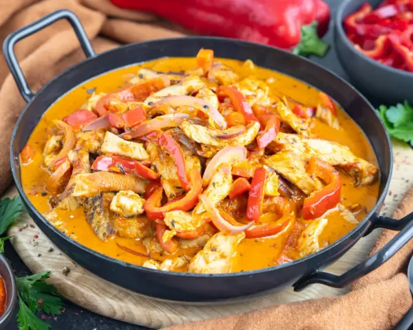 Ein einfaches Putengeschnetzeltes-Rezept mit Paprika und Zwiebeln in cremiger Sauce, serviert in einer Pfanne.
