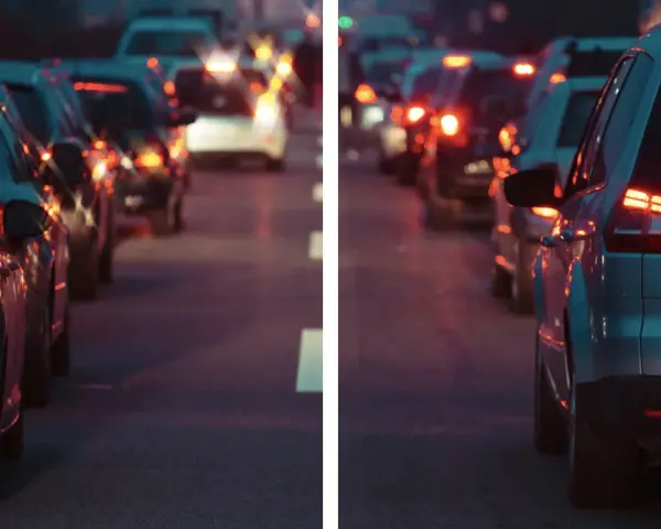 Traffico serale con luci sfocate, come vede le luci un miope. Le auto ferme creano un effetto di aloni luminosi.
