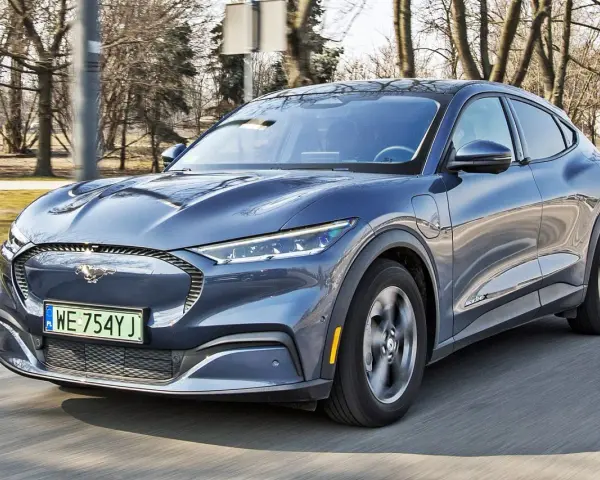Niebieski Ford Mustang Mach-E w ruchu drogowym, widok z przodu.