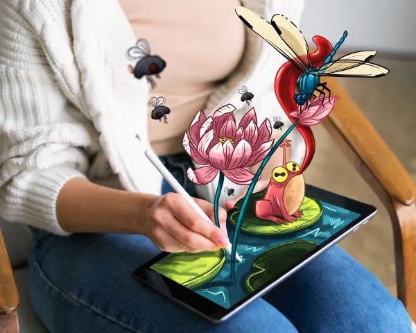 Osoba rysuje na tablecie za pomocą programu do rysowania na komputerze. Na ekranie pojawia się żaba, ważka i kwiat lotosu.