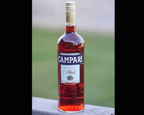 Butelka Campari, czerwonego likieru. Na etykiecie widnieje napis "Milano" i informacja o zawartości alkoholu, czyli campari ile procent.