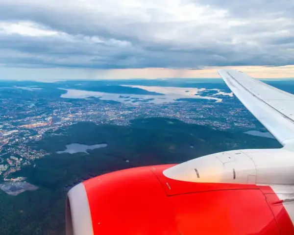 Widok z samolotu na Oslo i okoliczne fiordy, z widocznym skrzydłem i silnikiem.