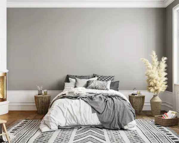 Dormitorio acogedor con chimenea encendida. El gris claro de la pared combina con blanco, negro y tonos tierra, creando un ambiente sereno.